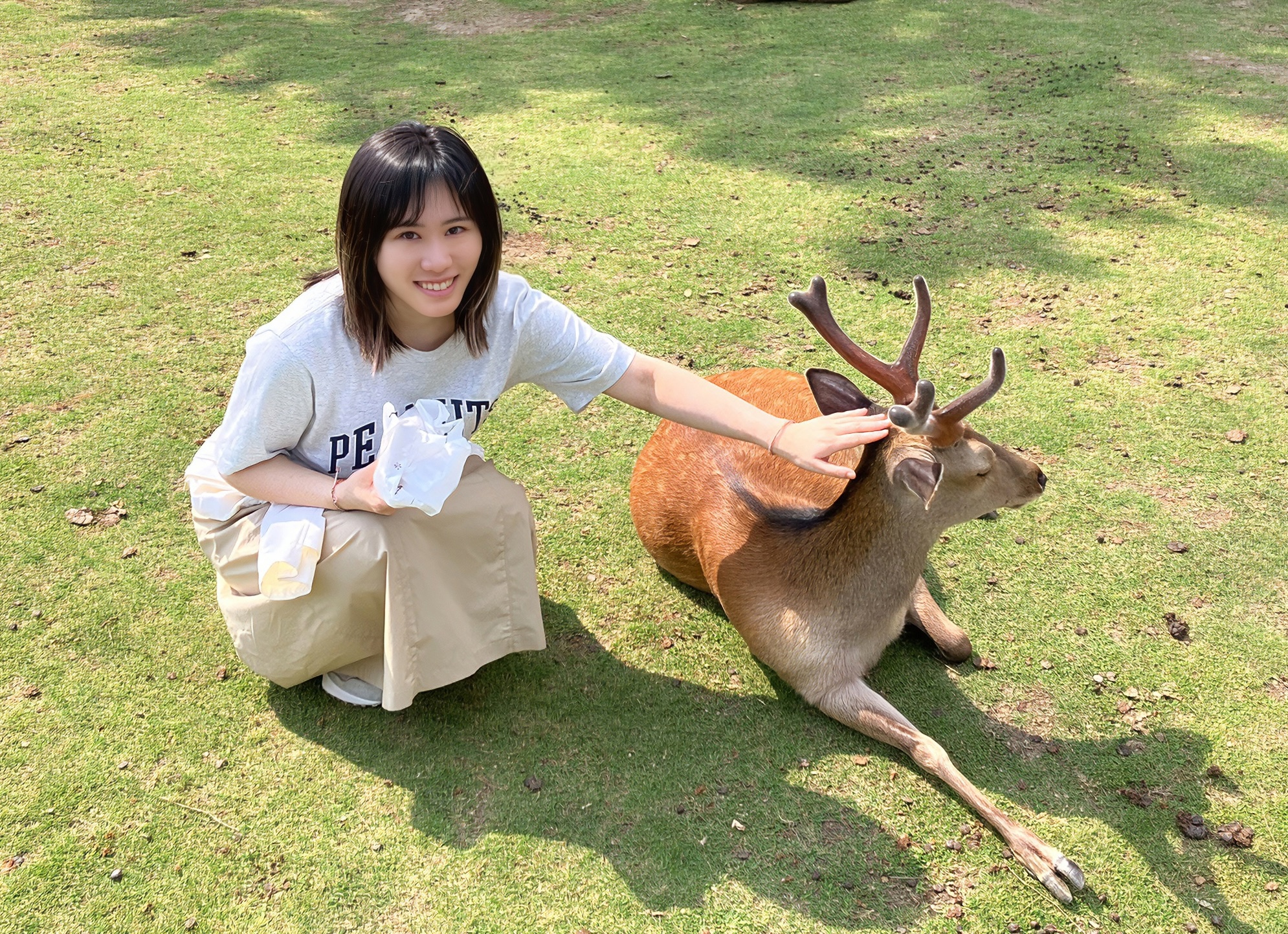 Jiayi Li sitting beside a deer